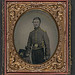 [Unidentified soldier in Union cavalry uniform with cavalry saber next to table with Cavalry Company D Hardee hat] (LOC)