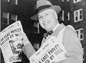 Photograph shows a man smiling broadly as he offers 'The News' daily newspaper for sale