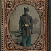 [Unidentified African American soldier in Union uniform and Company B, 103rd Regiment forage cap with bayonet and scabbard in front of painted backdrop showing landscape with river] (LOC)