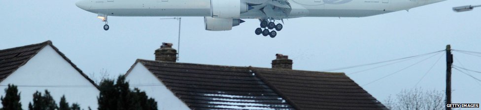 Low flying plane passing over rooftops on its way to land at Heathrow