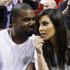 FILE - This Dec. 6, 2012 file photo shows singer Kanye West, left, talks to his girlfriend Kim Kardashian before an NBA basketball game between the Miami Heat and the New York Knicks in Miami. As the tabloids speculated over whether or not Jessica Simpson was expecting her second baby and the media zeroed in on Kate Middleton's pregnancy, Kardashian admits it was nice to be away from the glare of the spotlight as she was in the early stages of her own pregnancy. Now that the word is out, 32-year-old Kardashian says her motherly instincts have made her pull back from being so open about her personal life. (AP Photo/Alan Diaz, file)