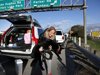 Heidi Blood carries her dog to the side of the road for a drink of water while waiting in line with her car along Interstate 5 north of Los Angeles on Friday, Jan. 11, 2013. The California Highway Patrol has partially reopened a 40-mile stretch of Interstate 5 north of Los Angeles that was closed for many hours due to snow. The CHP began escorting southbound motorists through the high mountain pass Friday morning. Northbound lanes are still closed. (AP Photo/Nick Ut)