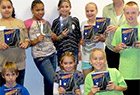 Young readers holding copies of The Exquisite Corpse