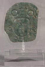 Plaque carved on two sides, with human face and animal headdress and deity in lotus position