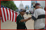 A man with an American flag shaking hands with another man on the National Mall.