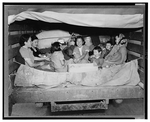 A group of Japanese-American women and children in the back of the truck.