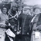 Photo: Aviator Eugene B. Ely.  With Captain Charles F. Pond, USN, Commanding Officer of USS Pennsylvania (Armored Cruiser # 4), shortly after landing his airplane on board the ship, in San Francisco Bay, California, 18 January 1911.  Ely's wife, Mabel, is second from the left. The woman at right is probably Captain Pond's wife.  Photograph from the Eugene B. Ely scrapbooks.  NHHC Photograph Collection, NH 77514.