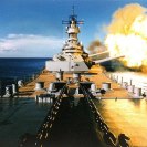 Photo: USS Wisconsin (BB-64).  Firing a broadside to port with her 16"/50 and 5"/38 guns, circa 1988-91.   NHHC Photograph Collection:   NH 97207 (Color).