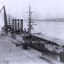 Photo: USS Pennsylvania (Armored Cruiser # 4).  At the Mare Island Navy Yard, California, in January 1911, after she had been fitted with a temporary wooden deck in preparation for Eugene Ely's airplane landing attempt. Ely landed his Curtiss pusher biplane on board the ship on 18 January, the first airplane landing on a warship.  The landing deck, 120 feet long and 30 feet wide, was inclined slightly to help slow the plane as it landed, and had a thirty-degree ramp at its after end.  The original glass plate negative for this image was cracked, producing the undulating horizontal line across the middle. Courtesy of the Mare Island Naval Shipyard, 1970.  NHHC Photograph Collection, NH 70595.