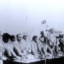 Photo: USS Pueblo incident, 1968.  Poor-quality photograph of USS Pueblo (AGER-2) crewmembers at a press conference in North Korea, taken sometime after they and their ship were captured off Wonsan on 23 January 1968.  Pueblo's Commanding Officer, Commander Lloyd M. Bucher, is standing in center.  NHHC Photograph Collection, NH 75557.