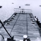 Photo: First airplane landing on a warship, 18 January 1911.  Eugene B. Ely's Curtiss pusher biplane about to touch down on the landing platform on USS Pennsylvania (Armored Cruiser # 4), during the morning of 18 January 1911. The ship was then anchored in San Francisco Bay, California.  Note the arresting system, consisting of lines stretched across the platform, with sandbag weights at each end. The lines, which were to be engaged by hooks on the airplane, were held above the deck by two rows of boards laid fore and aft. Canvas awnings were erected on both sides of the platform to catch the plane (and pilot) if it veered over the edge.  Photograph from the Eugene B. Ely scrapbooks.  NHHC Photograph Collection, NH 77507.