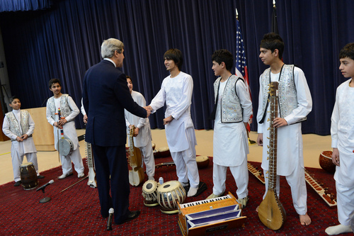 U.S. Secretary of State John Kerry surprises children from the Afghan National Institute of Music at their performance at the U.S. Department of State in Washington, D.C., February 4, 2013. [State Department photo/ Public Domain]