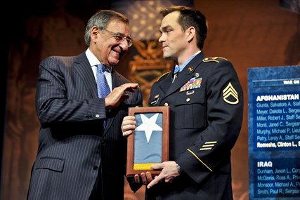 Defense Secretary Leon E. Panetta presents former Army Staff Sgt. Clinton L. Romesha with the Medal of Honor Flag at the Pentagon, Feb. 12, 2013. 
