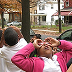 Local children from the Paul Public Charter School in Washington, D.C., take to the streets pretending to use binoculars in search of their urban forest