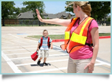A crossing guard helps a child.