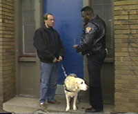 A police man talks with a man who uses a service animal