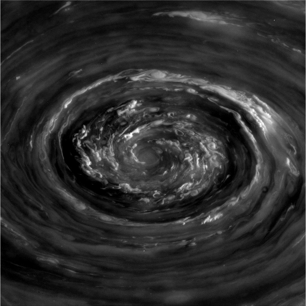 Image description: Massive cyclones, hundreds of times stronger than the most giant hurricanes on Earth, roil and swirl on the north pole of the planet Saturn. Taken from a distance of 250,000 miles by the Cassini orbiter, this view was aided by sunlight creeping over the north pole as the Saturnian seasons change.
Unlike hurricanes on Earth that are powered by the ocean&#8217;s heat and water, Saturn&#8217;s cyclones have no body of water at their bases. Yet, the eyes of Saturn&#8217;s and Earth&#8217;s storms look strikingly similar.
Just as condensing water in clouds on Earth powers hurricane vortices, the heat released from the condensing water in Saturnian thunderstorms deep down in the atmosphere may be the primary power source energizing the vortex.
See more from Cassini and Saturn.
Photo from NASA.