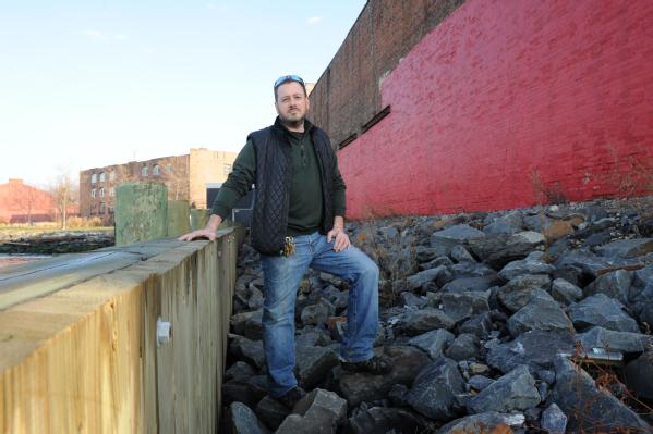 Brooklyn, N.Y., Dec. 4, 2012 -- Brian Robbins, owner of Cornell Paper and Box Company, Inc., stands next to his business which abuts Upper New York Bay. Robbins took the initiative to mitigate his property by building a bulk head wall to protect his property from storm surge. Although Robbins building was flooded due to Hurricane Sandy, he said that without the mitigation steps, he would have lost his whole building.
