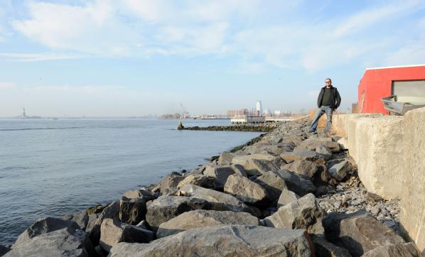 Brooklyn, N.Y., Dec. 4, 2012 -- Brian Robbins, owner of Cornell Paper and Box Company, Inc., stands next to his business which abuts Upper New York Bay. Robbins took the initiative to mitigate his property by building a stone wall to protect his property from storm surge. Although Robbins building was flooded due to Hurricane Sandy, he said that without the mitigation steps, he would have lost his whole building. 
