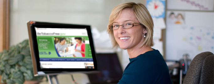 Mujer sentada delante de una pantalla de computadora que muestra el sitio BeTobaccoFree.gov