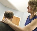 A chiropractor examines a patient.