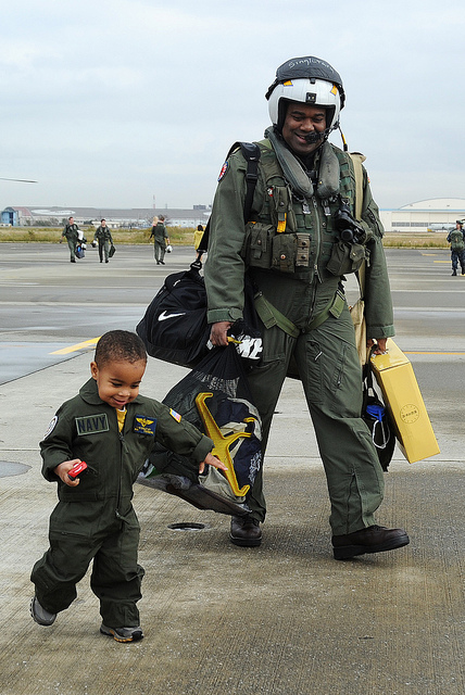 Image description: Lt. Cmdr. Chris Singletary walks with his son during a homecoming celebration at the Naval Air Facility in Japan.
Photo by Mass Communication Specialist 2nd Class Justin Smelley, U.S. Navy.