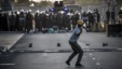 متظاهر بحريني يرمي الحجارة على عناصر الشرطة