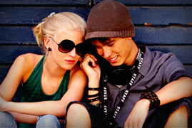 Teenage girl and boy sitting close together