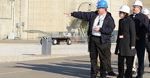 NRC Commissioner Kristine L. Svinicki (center) and NRC Senior Resident Inspector John Kramer (right) listen to Steven Sewell (left), Luminant’s director of Organizational Effectiveness, during their tour of the Comanche Peak nuclear power plant near Glen Rose, Texas. The reactor containment building is in the background.