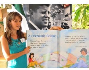 A Peace Corp Volunteer displaying one of the donated books