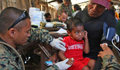 A United States Marine gives a child a vaccine at a village during Exercise Crocodilo 2012 in Timor-Leste 
