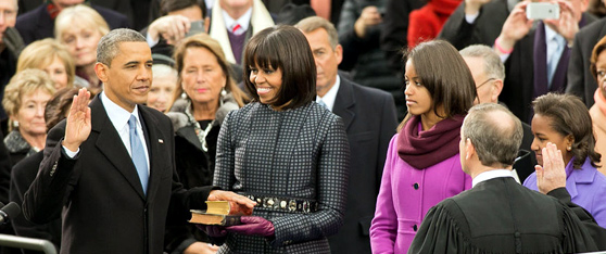 Prezident Obama skládá prezidentský slib do rukou předsedy Nejvyššího soudu USA Johna Robertse při veřejné slavnostní inauguraci před budovou Kapitolu v Washingtonu, D.C., 21. ledna 2013. Manželka Michelle drží bibli a dcery  Malia a Sasha sledují prezidentskou přísahu. (foto White House)