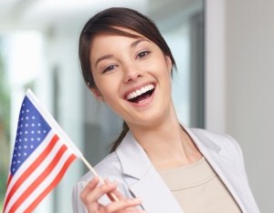 Image credit: <a href='http://www.123rf.com/photo_5823723_portrait-of-a-pretty-young-woman-holding-an-american-flag--smiling.html'>logos / 123RF Stock Photo</a>