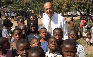 Fogarty Director Dr Roger I Glass with a large group of African children, posing for camera