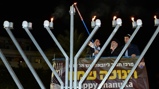 U.S. Ambassador to Israel Daniel Shapiro lights the menorah in Dizengoff Square in Tel Aviv, Israel, December 12, 2012. [State Department photo by Matty Stern/ Public Domain]