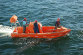 NOAA Ship Pisces crew members take a small boat
                    to shore to deliver water samples