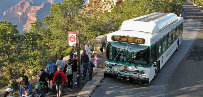 Photo of visitors at Grand Canyon National Park riding one of the free shuttle buses