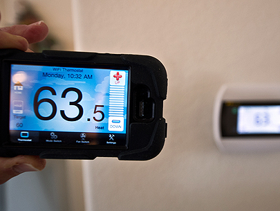 A photo of an iPhone app being used to connect to a home thermostat.