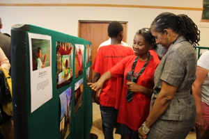 Ambassador James admiring photographs at the Teen Exhibition hosted by the Embassy at the Mbabane National Library (Photo Credit: State Department)