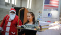 Marsha Ivins holds the Space Shuttle Cake as 'Santa Claus' looks on. (Embassy photo) 