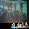 Four people sitting at table in front of large screen displaying group (Jiries Mansour)