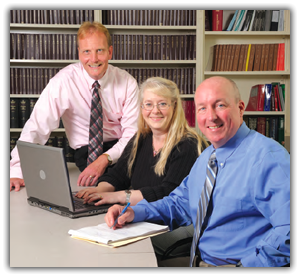 Three smiling professionals at a table