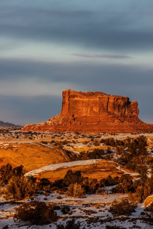 Monitor Butte sails through frosty clouds and over an icy sandstone sea at sunset, just beyond the Canyonlands National Park boundary.Photo: National Park Service 
