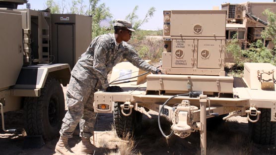 A 2nd Brigade, 1st Armored Division Soldier works with a 10kW Power Unit mounted on a Light Tactical Trailer during the Network Integration Evaluation 11.2 at White Sands Missile Range, N.M., in June 2011.