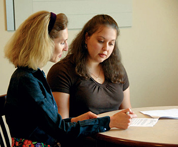 Two ladies talking over a document.