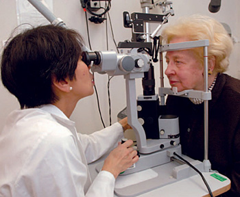 Lady doctor examining an eldarly woman's eye.