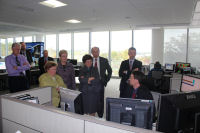 HPC's Dave Novak (seated) describes some of the products created by HPC forecasters to Senator Mikulski. Also in the picture from left to right are OPC forecaster Paul Vutkis, anonymous photographer, HPC Director Jim Hoke, NOAA Administrator Lubchenco, Acting Commerce Secretary Blank, NCEP Director Uccellini, and Acting GSA Administrator Tangherlini.