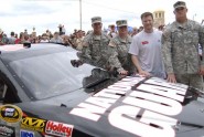 NASCAR superstar Dale Earnhardt Jr. poses with members of the Florida Army National Guard during an unveiling of the car he will race in the Coke Zero 400, during an event in Daytona Beach, Fla., July 1, 2009. Pictured with Earnhardt are Spc. Bower (left) 1st Lt. Anna Peck, and Staff Sgt. Glenn Wade. The custom designed car is black and features an Army Combat Uniform design. Photo by Tech. Sgt. Thomas Kielbasa