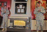 Lt. Col. John Rooney and Col. Matthew Hearon, both of the 164th Air Defense Artillery Brigade, applaud the receipt of a piece of the Pentagon that serves as a reminder and thank you for the unit’s service in support of the National Capital Region during the years following the September 11th attacks. Photo by Capt. Theresa R. DiPinto