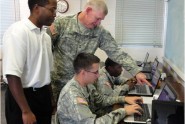 Maj/. Gen. James D. Tyre, Assistant Adjutant General for the Florida Army National Guard (standing, right), was on hand at the Daytona Beach Armed Forces Reserve Center recently to observe and assess the rollout of Operation KickStart, a Forward March program, and engage with program career coaches such as Frederic Triplett (standing, left), and Guardsmen to ensure the program's success. Photo by Ken Zeszutko